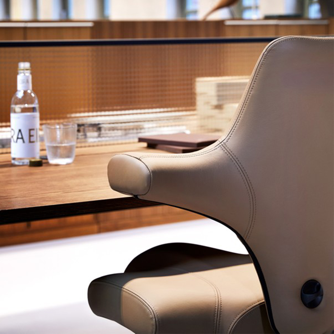 Close-up van een luxueuze lederen HÅG Capisco 8106 bureaustoel aan een bureau, met verfijnde details en ergonomisch design