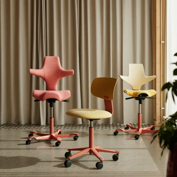 Three HÅG chairs with blush frames: on the left Capisco 8106 in Kvadrat Steelcut Quartet 0534, in the middle Tion 2140 with Harvest shell and Kvadrat Sisu 0405, on the right Capisco Puls 8020 with Sand shell and Kvadrat Steelcut Quartet 434